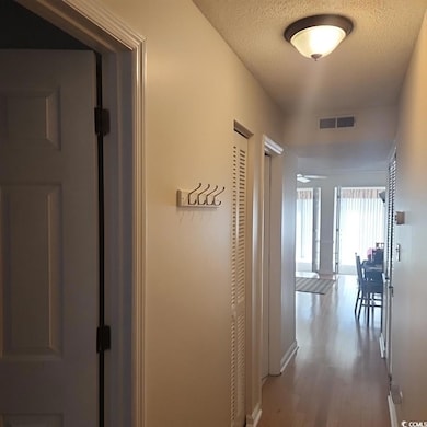 Hall featuring dark wood finished floors and a textured ceiling