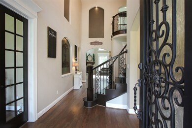 This well appointed foyer is accented with several art niches, wide plank hardwood floors and a spiral wood tread stairway with iron spindles. A picture perfect setting!