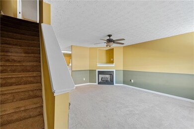 Unfurnished living room featuring ceiling fan, car