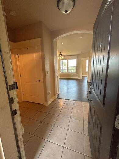 Hallway featuring arched walkways, baseboards, an