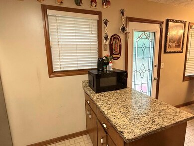 Kitchen featuring black microwave, baseboards, a p