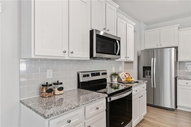Kitchen with light stone counters, tasteful backsp