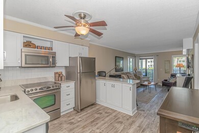 Kitchen with light hardwood / wood-style floors, backsplash, ceiling fan, white cabinets, and appliances with stainless steel finishes