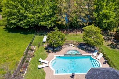 View of pool with a yard and an in ground hot tub