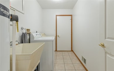 Laundry conveniently located off of kitchen with washer, dryer and utility sink.