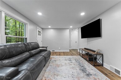 Additional view of the living area with flow to the hallway featuring neutral colors