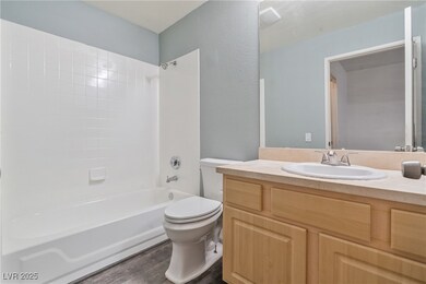 Bathroom with toilet, wood finished floors, shower