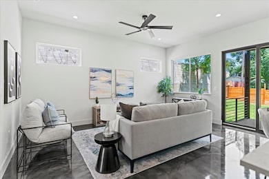 Living area featuring ceiling fan and recessed li