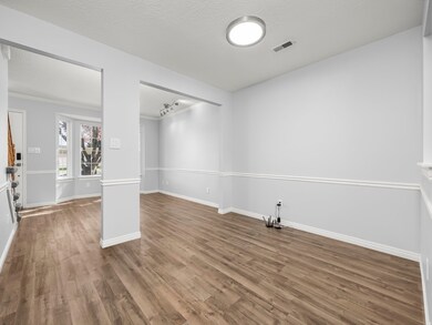 Empty room featuring wood finished floors, a textured ceiling, and ornamental molding