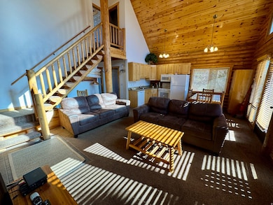 Living room featuring high vaulted ceiling, dark carpet, stairway, wooden ceiling, and a chandelier