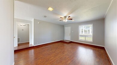 Unfurnished room with crown molding, dark hardwood