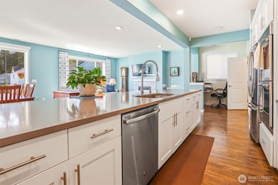 Gourmet kitchen with gas cooktop, double wall oven, french door refrigerator, stainless appliances, slab quartz countertops, center island eating bar that opens to the great room (living and dining rooms).