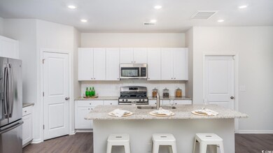 Kitchen with a breakfast bar area, visible vents, a sink, appliances with stainless steel finishes, and tasteful backsplash