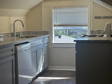 Kitchen featuring lofted ceiling, dark wood-style 