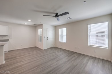 Unfurnished living room featuring ceiling fan, bas