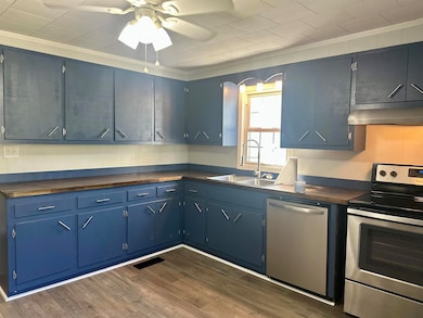 Kitchen featuring appliances with stainless steel finishes, crown molding, dark wood-style floors, blue cabinetry, and under cabinet range hood