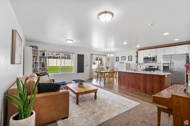 Living area featuring dark wood finished floors, a chandelier, and recessed lighting