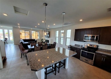 Kitchen with visible vents, a breakfast bar, a cen