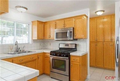 The kitchen has plenty of cabinets, including a pa
