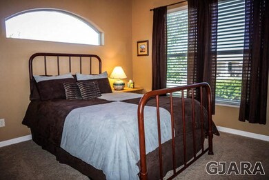 A guest bedroom with tall windows and an over-the-