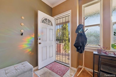 Foyer entrance featuring ornamental molding and light tile patterned flooring