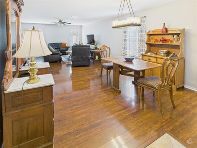 Dining area with ceiling fan and dark wood-style 