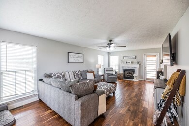 Spacious Living Room with Engineered Laminate Flooring, New Ceiling Fan and Natural Gas Log Fireplace.