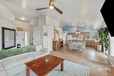 Living area with light carpet, ceiling fan, and high vaulted ceiling