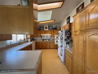 Kitchen featuring light floors, white appliances,