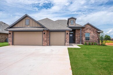 View of front of property featuring a garage, brick siding, driveway, a front yard, and board and batten siding