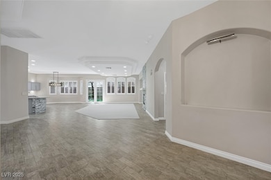 Unfurnished living room featuring recessed lighting, wood finished floors, and a chandelier