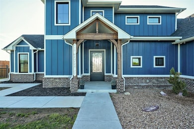 View of front of house featuring board and batten siding, a shingled roof, and covered porch
