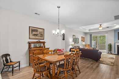 Dining room with light wood-style floors, a chande