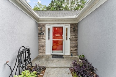 Property entrance featuring stone siding and stucco siding