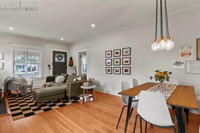 Dining area with updated chandelier and wood floor