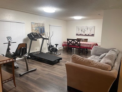 Workout room featuring a textured ceiling and dark wood-style flooring