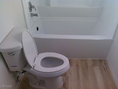 Bathroom featuring wood finished floors and a bath