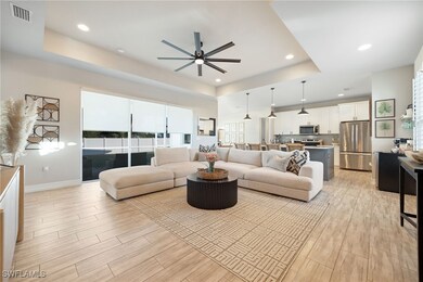 Living room featuring a tray ceiling and ceiling f