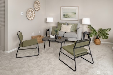 Open concept living with living room seating and dining area across from it next the second set of balcony doors.