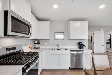 Whirlpool gas range, vented microwave and dishwasher. Photo is of model home. Colors and options may vary. Ask Sales Agent for details.