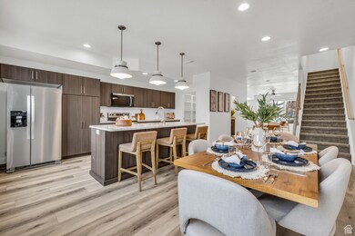 Dining room with stairway, light wood-style flooring, and recessed lighting