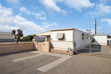 Manufactured / mobile home with fence, driveway, and a gate