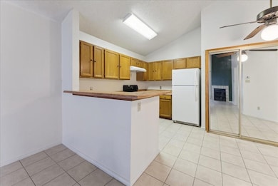 Kitchen featuring ceiling fan, light tile patterne