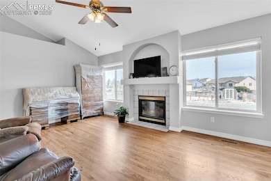 Living room featuring a ceiling fan, a fireplace, 