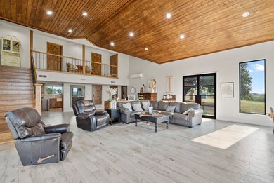 Living room with light hardwood / wood-style flooring, plenty of natural light, high vaulted ceiling, and wood ceiling