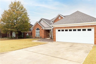 View of front of property featuring a front lawn, roof with shingles, driveway, and brick siding