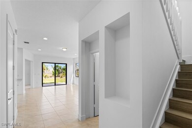 Hallway featuring stairs, light tile patterned flo