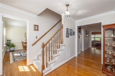 Foyer with hardwood floors opens to dining room, family room and living room includes a stairway to 2nd level