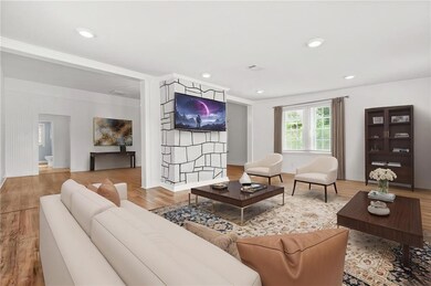 Living area with wood finished floors, baseboards, and recessed lighting