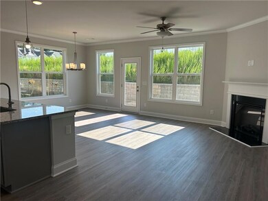 Unfurnished living room featuring dark wood finished floors, a ceiling fan, a glass covered fireplace, a chandelier, and crown molding